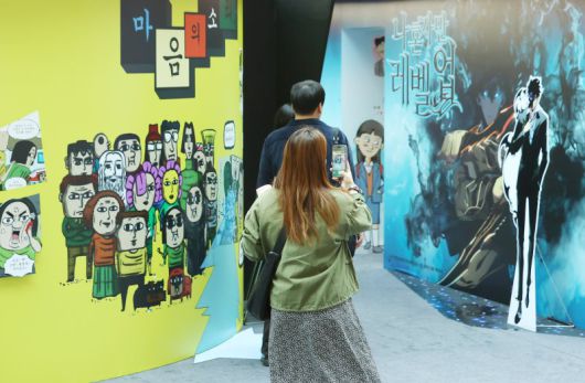 19일 서울 송파구 롯데월드 아이스링크에서 열린 '2025 월드 웹툰 페스티벌'을 찾은 관람객들이 웹툰 기획 전시를 살펴보고 있다. 연합뉴스