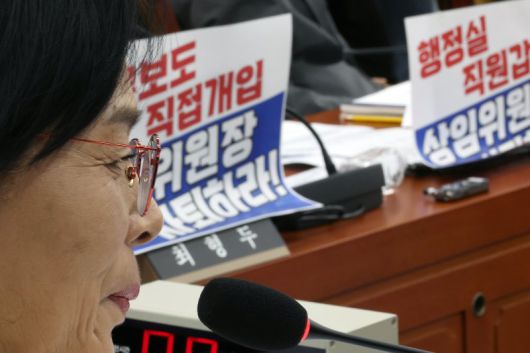 최민희 국회 과학기술정보방송통신위원회 위원장이 지난 29일 서울 여의도 국회에서 열린 국정감사에서 미소를 머금고 있다. 국민의힘 의원들이 노트북에 부착한 최 위원장 사퇴 촉구 피켓이 보인다. /사진=뉴시스