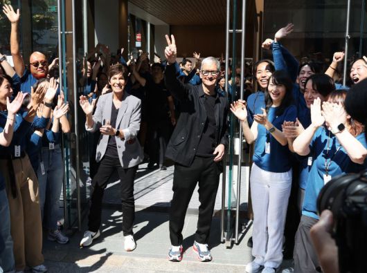 팀 쿡(가운데) 애플 최고경영자(CEO)가 9월 26일(현지시간) 일본 도쿄의 애플 긴자 스토어의 매장 재개장 기념식에 참석해 손을 흔들고 있다. AFP 연합