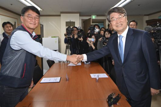 김지형 경제사회노동위원회 위원장(오른쪽)이 25일 서울 중구 전국민주노동조합총연맹(민주노총)을 방문해 양경수 민주노총 위원장과 악수하고 있다. 연합뉴스