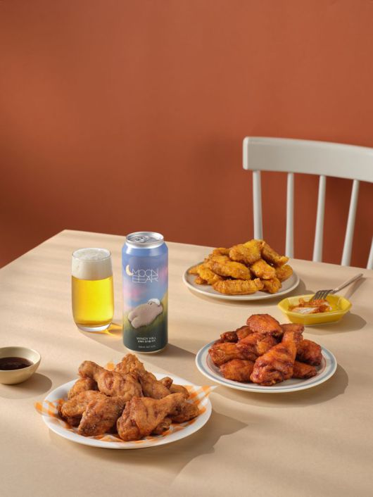 교촌치킨과 페어링한 문베어 맥주가 식탁 위에 올려져 있다. 교촌에프앤비 제공