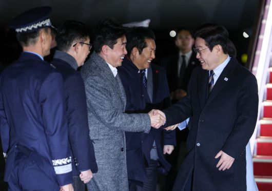 중국 국빈 방문 일정을 마치고 귀국한 이재명 대통령이 7일 경기 성남 서울공항에서 환영나온 강훈식 비서실장과 인사하고 있다. 뉴스1