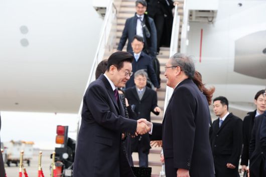 한일 정상회담을 위해 일본을 방문한 이재명 대통령이 13일 오사카 간사이 국제공항에 도착해 환영 인사들과 인사하고 있다. 뉴시스