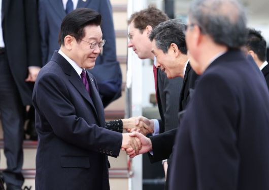 한일 정상회담을 위해 일본을 방문한 이재명 대통령이 13일 오사카 간사이 국제공항에 도착해 환영 인사들과 인사하고 있다. 뉴시스