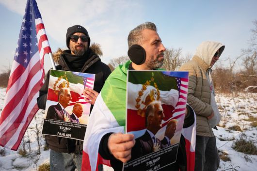 14일(현지시간) 이란의 이슬람 정권에 반대하는 시위대가 루마니아 부크레슈티의 미국 대사관 앞에서 이슬람 정권에 축출된 이란의 레자 팔레비 왕세자(왼쪽)와 도널드 트럼프 미국 대통령이 나란히 그려진 포스터를 들고 있다.AP연합뉴스