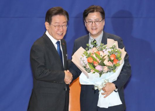 이재명 대통령이 더불어민주당 대표 당시 서울 여의도 국회 의원회관에서 열린 '제22대 국회 더불어민주당 제1기 원내대표 선출 당선자 총회'에서 임기를 마친 홍익표 전 원내대표에게 꽃다발을 전달하고 있다. 뉴스1