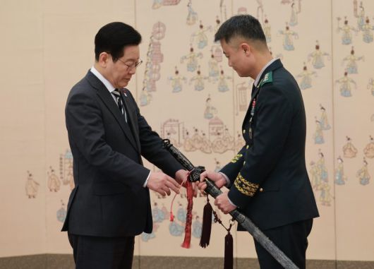 이재명 대통령이 16일 청와대 본관에서 열린 3성 장군 진급·보직 신고 및 수치 수여식에서 박성제 육군특수전사령부 사령관의 삼정검에 수치를 달아주고 있다. 뉴시스