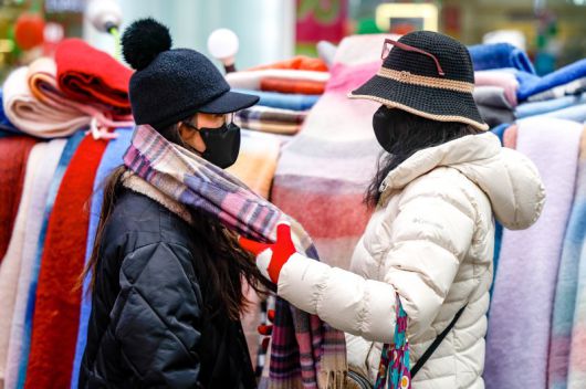 [서울=뉴시스] 정병혁 기자 = 서울 중구 명동을 찾은 여행객이 목도리를 고르고 있다. 2025.12.27. jhope@newsis.com /사진=뉴시스
