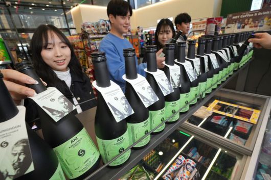 세븐일레븐 모델이 말차 사케 '아키그린'을 소개하고 있다. 세븐일레븐 제공