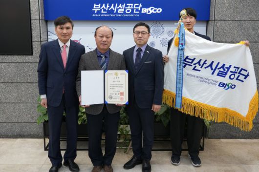 21일 부산시설공단 본사 로비에서 공단 임재선 경영본부장(가운데) 등이 표창을 들고 기념촬영하고 있다. 부산시설공단 제공