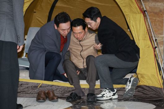 이레째 단식농성 중인 장동혁 국민의힘 대표가 21일 서울 여의도 국회 로텐더홀에서 의료진에게 검진을 받은 뒤 부축을 받으며 텐트에서 나오고 있다. 뉴시스