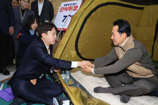 통일교·공천헌금 '쌍특검' 수용을 요구하며 단식 7일 차를 맞은 국민의힘 장동혁 대표(오른쪽)가 21일 국회 로텐더홀 단식 농성장을 찾은 개혁신당 이준석 대표와 손을 맞잡으면서 인사하고 있다. 연합뉴스