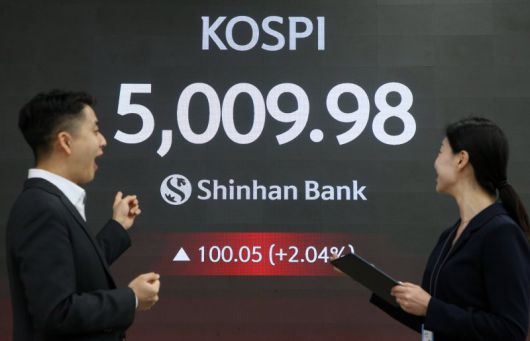 코스피가 장중 5000을 넘어선 가운데 22일 서울 중구 신한은행 본점 로비에서 딜러들이 미소 짓고 있다. 신한투자증권 제공