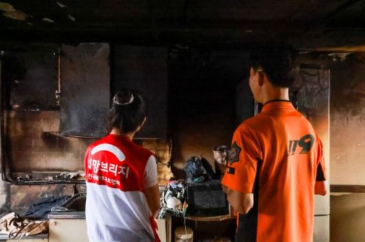 희망브리지 직원이 지난해 서울 광진구에서 발생한 화재 피해 세대를 방문해 광진소방서 화재조사관으로부터 화재 피해 상황에 대한 설명을 듣고 있다. 희망브리지 제공