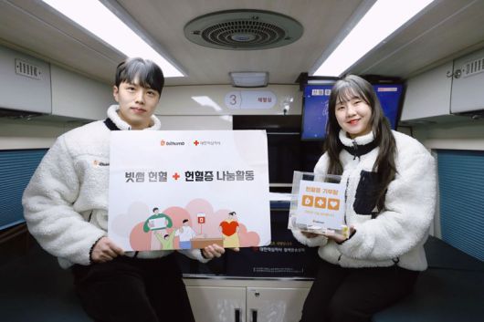 빗썸 임직원이 지난 21일 서울 강남구 삼원타워 앞에 마련된 헌혈버스에서 헌혈 나눔활동을 알리고 있다. 빗썸 제공