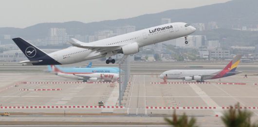 지난 2023년 4월 24일 오후 인천국제공항 주기장에 세워진 국내 항공기 위로 외국 항공사 항공기가 이륙하고 있다. (자료사진) 연합뉴스