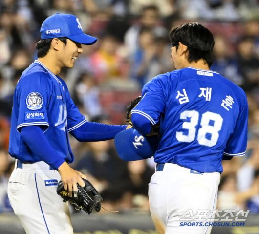 이재현이 9회말 수비를 앞두고 심재훈의 글러브와 장비를 건네주고 있다.