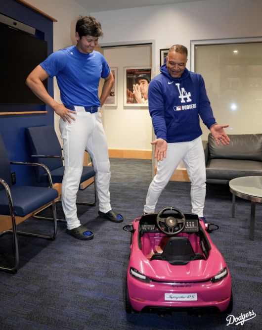 데이브  로버츠 감독이 5일(한국시각) 다저스타디움에서 열린 뉴욕 메츠전을 앞두고 오타니 쇼헤이를 감독실로 불러 그의 딸을 위한 유아용 포르셰 자동차를 선물하며 자랑하고 있다. 사진=LA 다저스 구단 X 계정