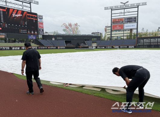 그라운드 관리팀 직원들이 경기장을 살피고 있다.
