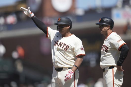 San Francisco Giants' Rafael Devers, left, gestures next to first base coach Mark Hallberg after hitting a single during the eighth inning of a baseball game against the Cleveland Guardians in San Francisco, Thursday, June 19, 2025. (AP Photo/Jeff Chiu)        <저작권자(c) 연합뉴스, 무단 전재-재배포, AI 학습 및 활용 금지>