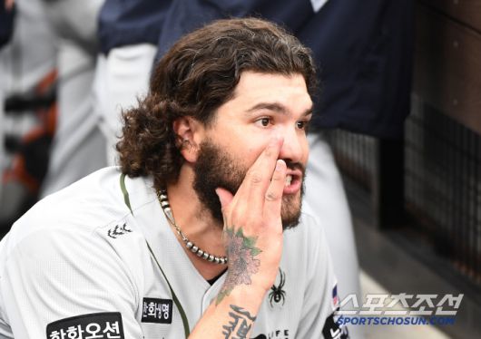 더그아웃에 들어온 폰세가 출입구 쪽에 쪼그려 앉아 1루주자 최주환을 부르고 있다.