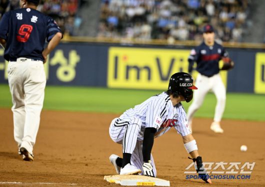 홍민기의 빗나간 견제구를 몸으로 막아낸 정훈, 공에 맞은 옆구리를 어루만지고