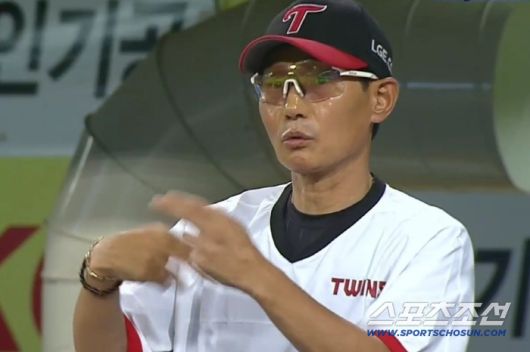 LG 포수 박동원이 팔꿈치를 가리키며 벤치에 유영찬의 팔에 문제가 있음을 알리자 염경엽 감독이 교체해야 하냐고 신호를 보내고 있다. SPOTV2 중계화면 캡쳐