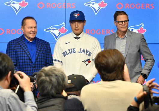 Kazuma Okamoto, center, the Toronto Blue Jays newest signing, dons a jersey at an introductory press conference with his attorney Scott Boras, left, and Blue Jays general manager Ross Atkins at Rogers Centre in Toronto, Canada, on Tuesday, Jan. 6, 2026. (Jon Blacker/The Canadian Press via AP) MANDATORY CREDIT        <저작권자(c) 연합뉴스, 무단 전재-재배포, AI 학습 및 활용 금지>