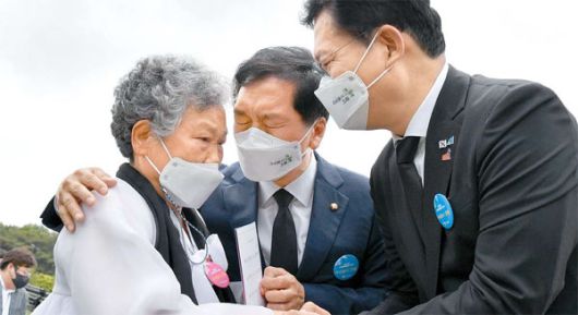 5·18민주화운동 41주년을 맞은 18일 송영길 더불어민주당 대표(오른쪽)와 김기현 국민의힘 대표 권한대행(가운데)이 국립5·18민주묘지에서 기념식 행사를 마친 뒤 유가족을 위로하고 있다.  [사진 = 연합뉴스]