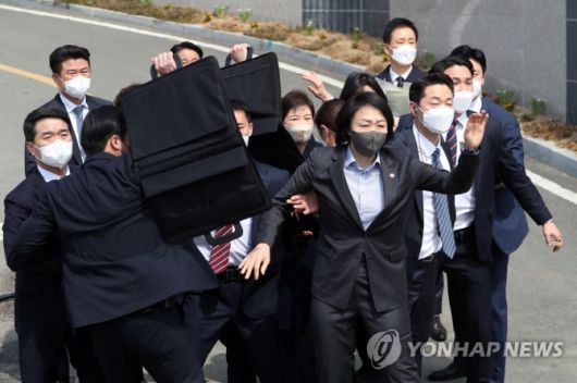 24일 오후 박근혜 전 대통령이 대구 달성군 사저에 도착해 대국민 담화문을 밝히던 중 갑자기 소주병이 날아들자 경호원들이 박 전 대통령을 둘러싸고 있다. [사진 출처 = 연합뉴스]