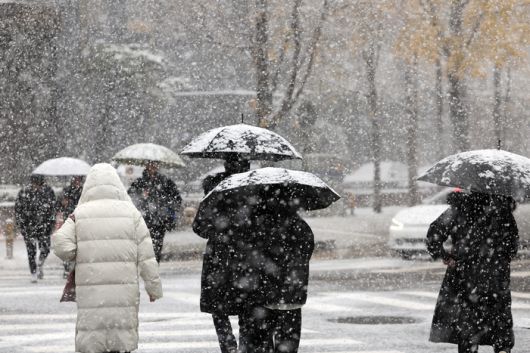 지난달 27일 오후 우산을 쓴 시민들이 서울 여의도의 한 거리를 지나고 있다. [사진 = 연합뉴스]