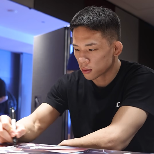 박현성이 UFC312 호주 시드니 개최 홍보 포스터에 친필로 서명하고 있다. 사진=TKO