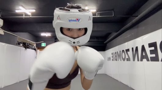 K-POP 걸그룹 ‘여자아이들’ 리더 소연이 헤드기어와 복싱 글러브를 착용하고 정찬성의 코리안좀비MMA 체육관에서 운동하고 있다. 오른쪽에 Korean Zombie 문구가 보인다. 사진=인스타그램 tiny.pretty.j 영상 화면