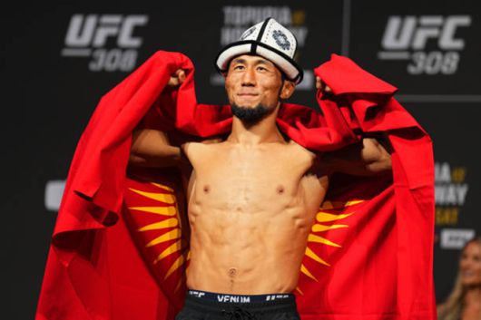 믹티베크 오롤바이 우울루가 2024년 10월 아랍에미리트 아부다비 에티하드 아레나 UFC 308 공개 계체 행사에서 키르기스스탄 국기를 들며 촬영에 응하고 있다. 사진=TKO