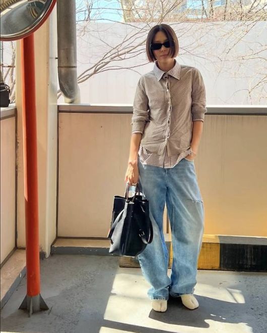 김나영은 내추럴한 체크 셔츠와 찢어진 디테일이 돋보이는 와이드 데님 팬츠로 편안하면서도 세련된 나들이룩을 완성했다.사진=김나영 SNS