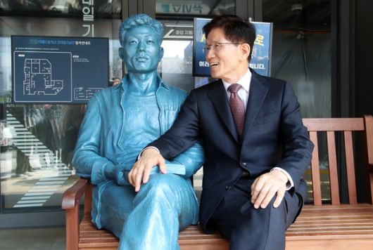 김문수 전 고용노동부 장관이 10일 서울 종로구 전태일기념관에 설치된 전태일 동상 옆에 앉아 있다.  [사진출처 = 공동취재]