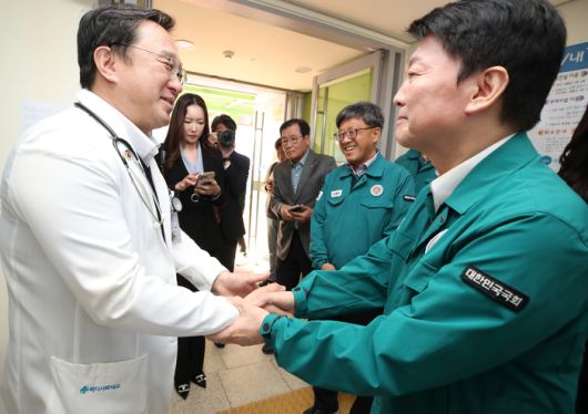 안철수 국민의힘 의원이 지난 10일 오후 경북 영덕군 국립청소년해양센터에 마련된 산불 피해 이재민 대피소를 찾아 의료봉사에 참여한 김창호 칠곡경북대병원 응급의학과 교수와 만나 감사의 뜻을 표하며 격려하고 있다. [사진출처=뉴스1]