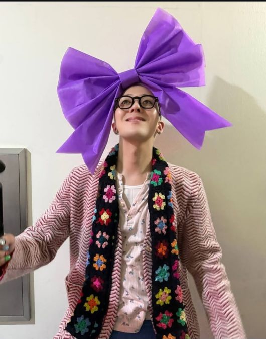 보랏빛 초대형 리본을 머리에 장식한 지드래곤의 모습이 담겼다. 사진=지드래곤 SNS