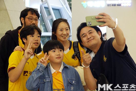 4월 20일 광주에서 인천공항까지 올라와 광주 FC 선수들에게 힘을 불어넣은 김진옥 씨(사진 가운데)의 가족이 유명 가수 ‘노라조’ 조 빈과 사진을 찍고 있다. 조 빈은 광주 FC 팬뿐 아니라 K리그 모든 팬의 사인, 사진 요청을 거절하지 않는 ‘특급 팬 서비스’로도 유명하다. 사진=이근승 기자