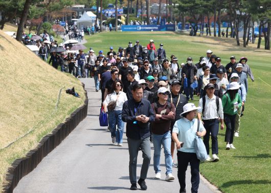 KPGA 투어 우리금융 챔피언십에서 선수들의 경기를 보기 위해 서원밸리 컨트리클럽 1번홀을 걷고 있는 관중들. KPGA