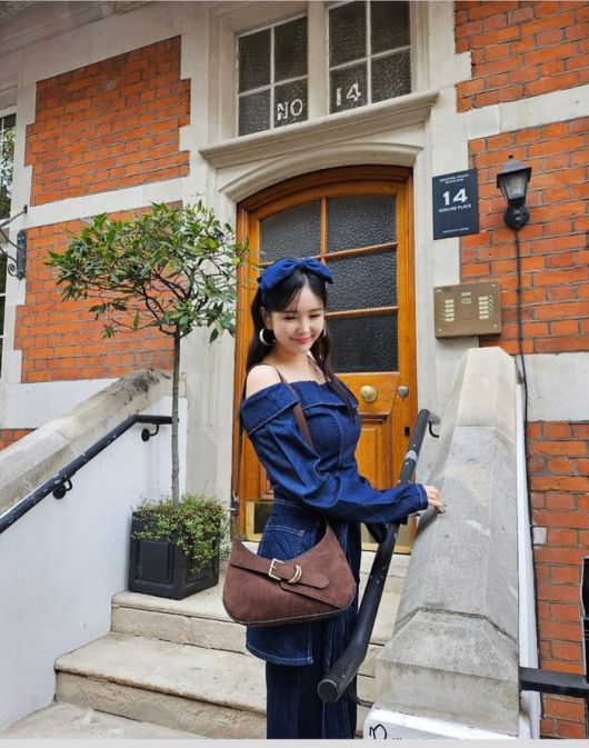 장영란은 영국 런던 도심 거리와 클래식한 건물을 배경으로, 데님 오프숄더 원피스에 브라운 스웨이드 숄더백, 그리고 네이비 리본 헤어밴드까지 더해 우아하면서도 러블리한 무드를 동시에 완성했다. 사진=장영란 SNS