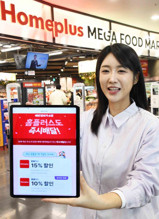 모델이 지난달 29일 서울 강서구 ‘홈플러스 메가 푸드 마켓 라이브 강서점’에서 배달의민족과 선보인 대형마트 퀵커머스 서비스를 소개하고 있다. [사진 = 홈플러스 제공]