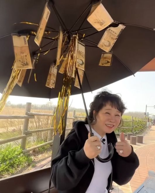 우산 아래에서 환하게 웃는 모습은 말 그대로 ‘현금은 행복이다’를 실감케 했다.사진=미자 SNS