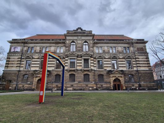 거대한 현대미술관 알버티눔 우측의 모습. 공원에는 설치된 마렉 솝치크의 직사각형 무지개 형태의 문 조각, [예술가의 예우]. 미술관의 포용성을 상징하며 2024년 설치됐다. ©김슬기