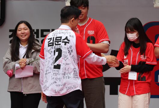 청년들의 응원 메시지가 적힌 옷을 입은 김문수 국민의힘 후보가 19일 청계광장에서 청년들을 만나고 있다. 이충우 기자