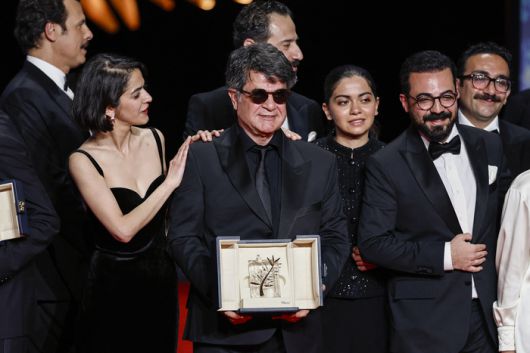 영화 ‘단순한 사고’로 올해 제78회 칸영화제 황금종려상을 수상한 이란 반체제 영화감독 자파르 파나히가 시상식에서 동료의 축하를 받고 있다. [로이터·연합뉴스]