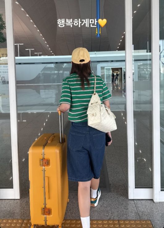 초록색 스트라이프 티셔츠에 데님 반바지, 옐로우 볼캡과 캐리어까지 맞춘 빈티지한 공항룩으로, 캐주얼하면서도 센스 있는 공항 패션을 선보였다.사진=신지 SNS