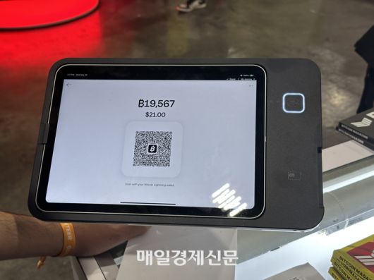 스퀘어의 비트코인 결제 단말기 비트코인 2025 행사장에 마련된 기념품 가게에서 물품 결제시 나오는 화면. 1만9567사토시에 구입 가능하다고 표기되어 있다. QR코드를 인식한 뒤 송금 버튼을 누르면 결제가 즉시 완료된다. <이종화 기자>