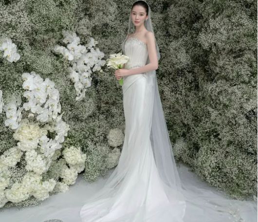 아이린은 순백의 오프숄더 웨딩드레스를 입고, 눈부신 미소를 머금은 채 포즈를 취하고 있다.사진=아이린 SNS