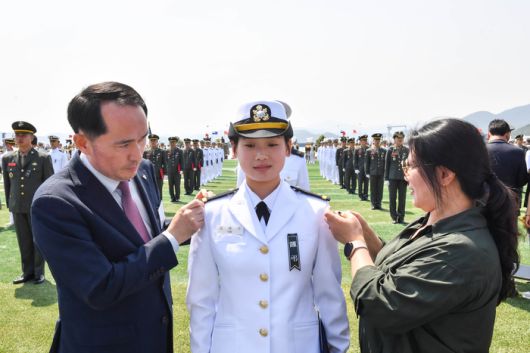 30일 경남 창원시 진해구 해군사관학교에서 열린 제138기 해군·해병대 사관후보생 수료 및 임관식에서 천안함 46용사 고(故) 김태석 해군원사의 장녀인 김해나 소위가 어머니와 최원일 전 천안함장에게 계급장을 수여받고 있다. [사진 = 해군]